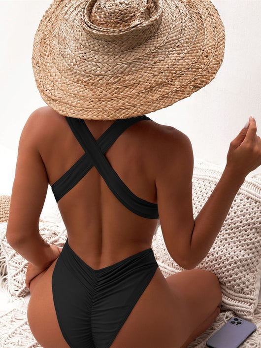 Woman in a black one-piece swimsuit with a deep V-neck and criss-cross waist cutouts, wearing a straw hat. - Image 16