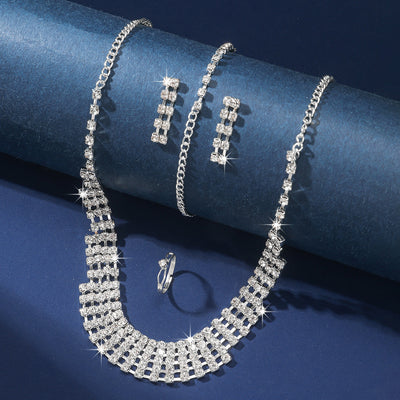 Sparkling four-piece jewelry set with a rhinestone necklace, bracelet, drop earrings, and a simple band ring on a model. - Image 4