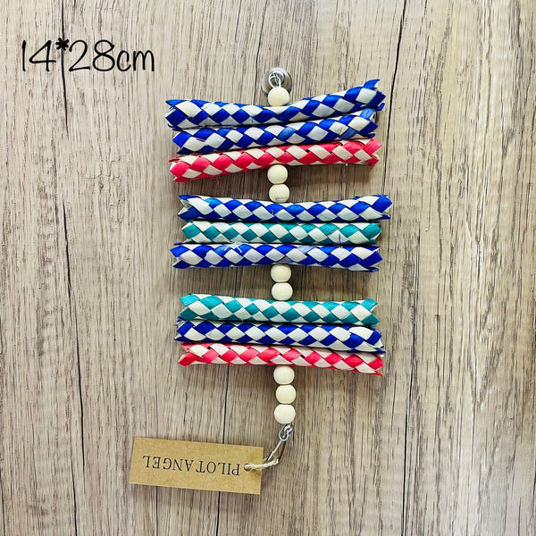 Colorful parrot toy with woven blue, white, and red paper strips, filled with bright crinkly paper, on a wooden background.