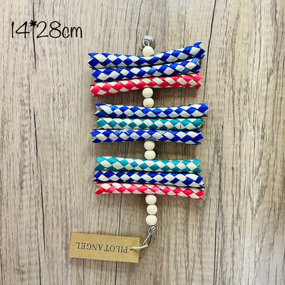 Colorful parrot toy with woven blue, white, and red paper strips, filled with bright crinkly paper, on a wooden background.