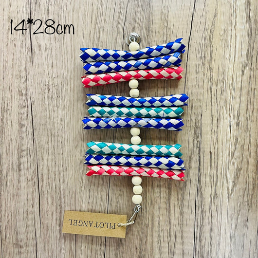 Colorful parrot toy with woven blue, white, and red paper strips, filled with bright crinkly paper, on a wooden background.