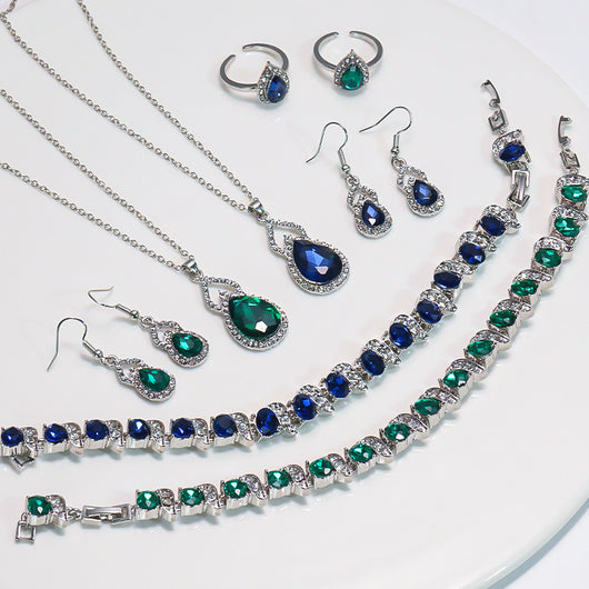 Light luxury jewelry set with silver-tone necklace, dangle earrings, open ring, and bracelet, all featuring emerald green teardrop and oval stones with clear rh - Image 9