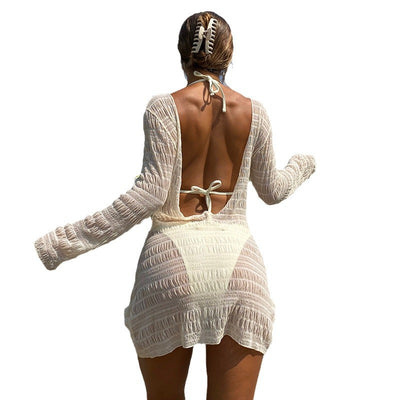 Woman from behind wearing a black long-sleeve, open-back smocked cover-up over a bikini bottom, walking outdoors. - Image 5