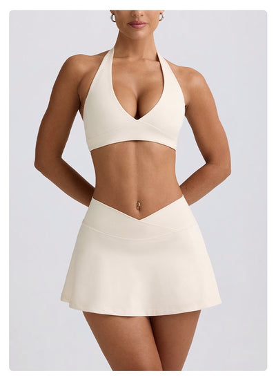 Light pink halter neck sports bra and high-waisted leggings workout set on a model. - Image 45