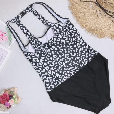 Woman in a black and white leopard print one-piece swimsuit with a halter neck and black bottoms, wearing sunglasses. - Image 11