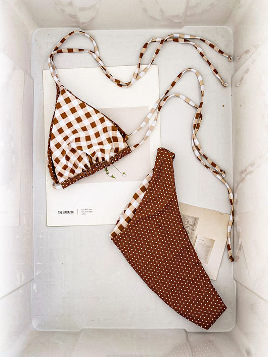 Retro brown and white plaid triangle bikini top with matching polka-dot bottoms, displayed flat with accessories. - Image 12