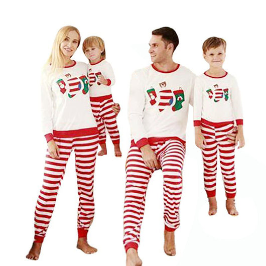 Father and son wearing matching Christmas pajamas with white long-sleeved tops featuring stocking prints and red and white striped pants. - Image 11