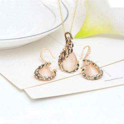Rose gold tone bridal jewelry set with a necklace and stud earrings, each featuring a large blue teardrop gem and clear accents. - Image 4