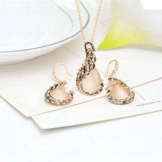 Rose gold tone bridal jewelry set with a necklace and stud earrings, each featuring a large blue teardrop gem and clear accents. - Image 4
