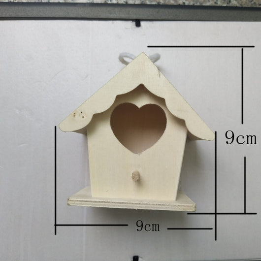 Unfinished wooden birdhouse with a circular entrance hole and a small perch, held by a hand. - Image 4