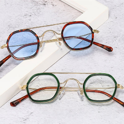 Green hexagonal frame sunglasses with blue to peach gradient lenses and gold-tone double bridge and temples.