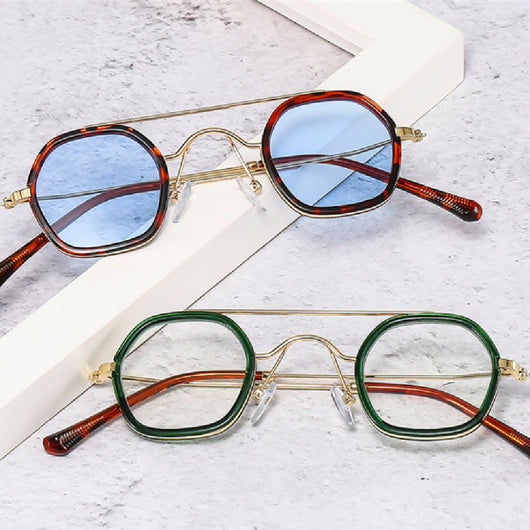 Green hexagonal frame sunglasses with blue to peach gradient lenses and gold-tone double bridge and temples.