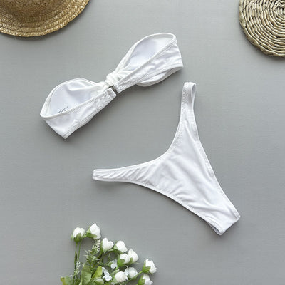 Woman wearing a black bandeau bikini top with a front knot and matching high-cut bottoms, accessorized with gold jewelry. - Image 16