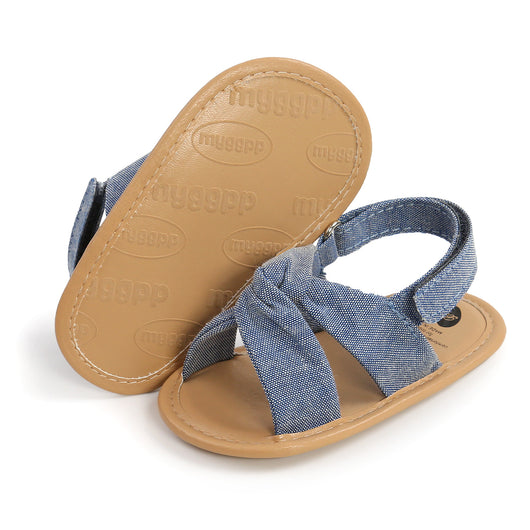 Black baby sandals with knotted cross straps and a matching black floral headband on a white background. - Image 33
