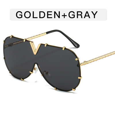 Oversized V-shaped sunglasses with a gold metal frame, white accents, clear lenses, and decorative rivets. - Image 6