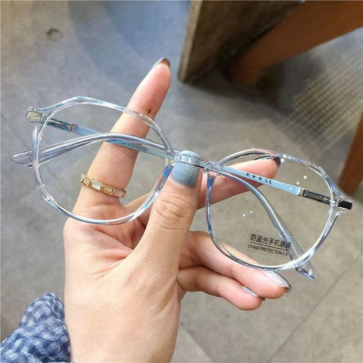 Transparent blue anti-blue light glasses with a vintage round frame and clear lenses, held by a hand. - Image 6