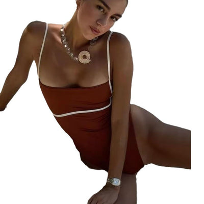 Woman in a brown and beige one-piece swimsuit with thin straps and white piping, sitting on a boat. - Image 15