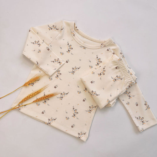 Light yellow infant long-sleeved pajama set with milk bottle and cookie print, suitable for homewear.
