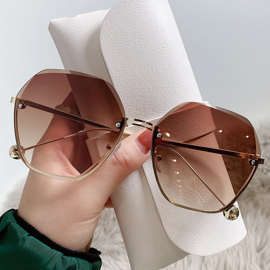 Elegant fashion sunglasses with gold metal frames and pink gradient lenses, held against a white case. - Image 5