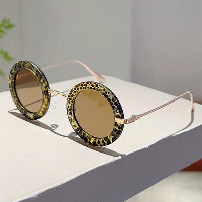 Small frame oval fashion sunglasses with black frames and vibrant orange lenses, held by a hand. - Image 18