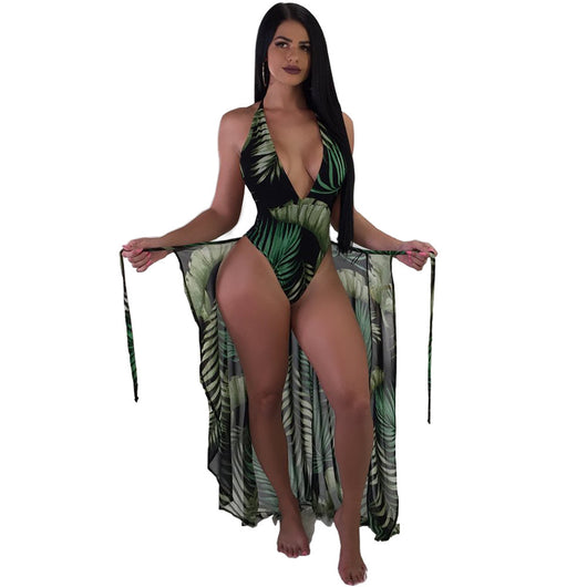 Woman in a black one-piece swimsuit with green leaf print, plunging V-neck, and matching sheer sarong cover-up. - Image 11