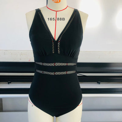 Women's plus size black one-piece swimsuit with a V-neckline and mesh fabric stitching details at the bust and waist. - Image 4