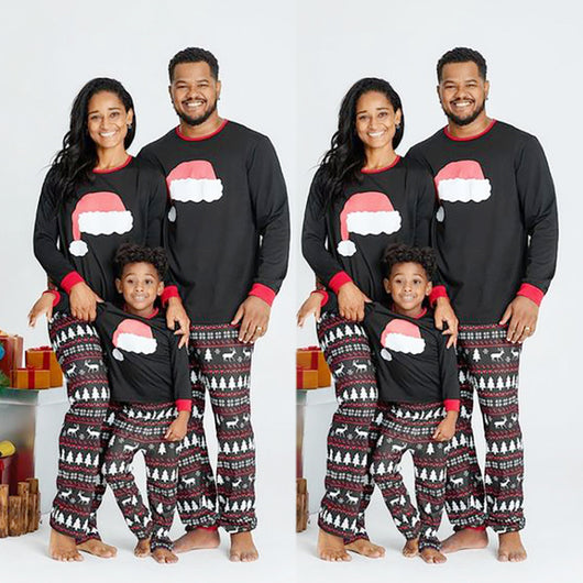 Family of three wearing matching black Christmas pajamas with Santa hat tops and reindeer fair isle pants. - Image 11