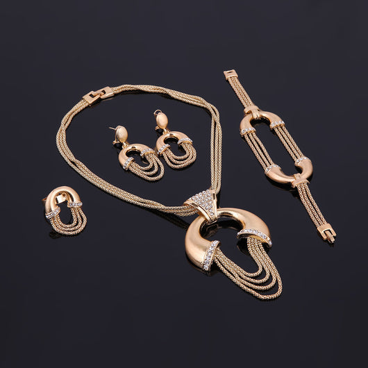 Four-piece gold-tone bridal jewelry set with crystal accents, including a statement necklace, dangling earrings, bracelet, and ring. - Image 9