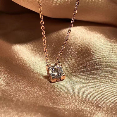 Delicate silver-colored chain necklace with a single square-cut clear stone pendant in a four-prong setting on a woman's neck. - Image 3