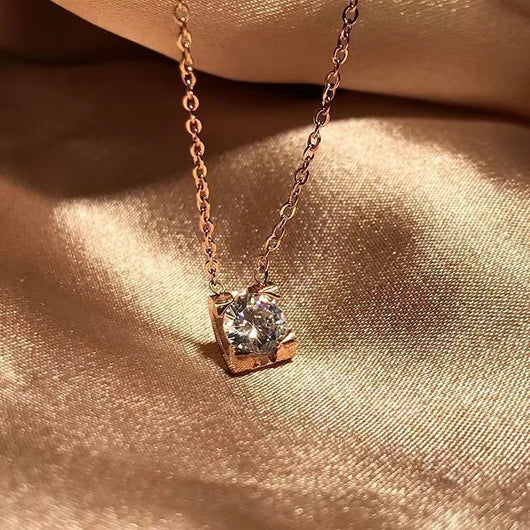 Delicate silver-colored chain necklace with a single square-cut clear stone pendant in a four-prong setting on a woman's neck. - Image 3