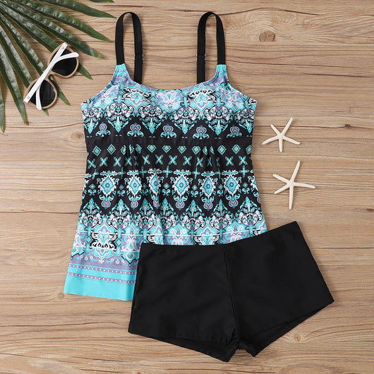 Woman in a black and white abstract print tankini top with black swim shorts on a sunny beach. - Image 12