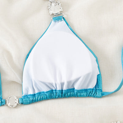 Shiny blue two-piece bikini with rhinestone-embellished halter top and high-cut bottom, laid flat with a straw hat and sunglasses. - Image 17