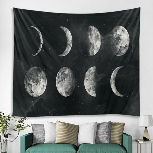 Black tapestry featuring a white and grey moon phase design, depicting the lunar cycle, hanging on a white wall.