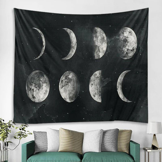 Black tapestry featuring a white and grey moon phase design, depicting the lunar cycle, hanging on a white wall.