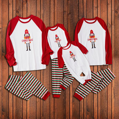 Matching family Christmas pajamas with white raglan tops, red sleeves, and a nutcracker graphic, paired with red, green, and white striped pants. Includes adult