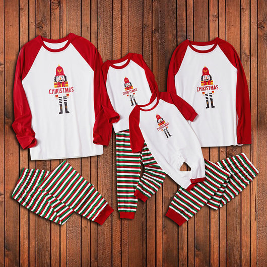 Matching family Christmas pajamas with white raglan tops, red sleeves, and a nutcracker graphic, paired with red, green, and white striped pants. Includes adult