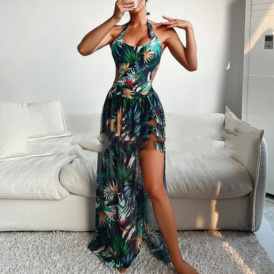 Yellow tropical print three-piece bikini set with halter top, high-waisted bottoms, and long cover-up skirt with high slit.