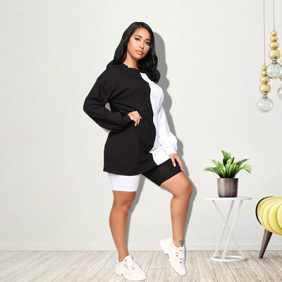 Woman wearing a black and white color-block long-sleeve top and matching shorts with white sneakers. - Image 25