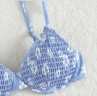 Periwinkle blue two-piece swimsuit with white floral pattern and ruched texture, featuring an underwire bikini top and high-cut bottoms. - Image 17