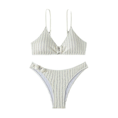Women's white ribbed V-neck bikini with a front tie top and side ring bottoms, modeled by the ocean. - Image 5