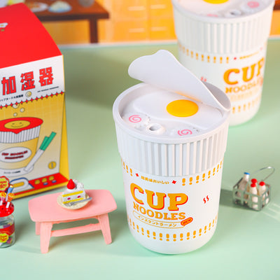 White and blue cup noodle shaped USB humidifier with a removable lid, ideal for desktop or bedroom use.