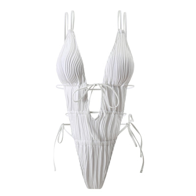 Woman in a light yellow ribbed one-piece tie-front backless bikini relaxing on a sandy beach by the ocean. - Image 4