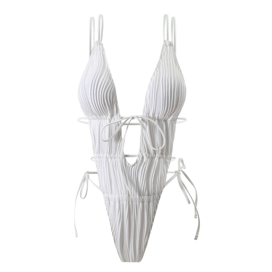 Woman in a light yellow ribbed one-piece tie-front backless bikini relaxing on a sandy beach by the ocean. - Image 4