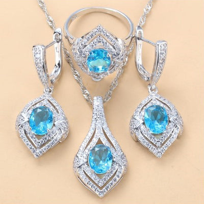 Silver-toned three-piece jewelry set with clear oval and round gems, including a necklace, dangle earrings, and a ring. - Image 20