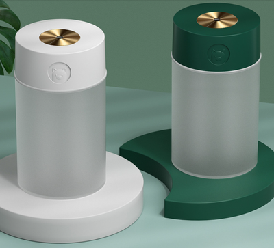 White cylindrical humidifier with a gold nozzle emitting mist, featuring a subtle bear emblem. Includes five aromatherapy oil bottles. - Image 21