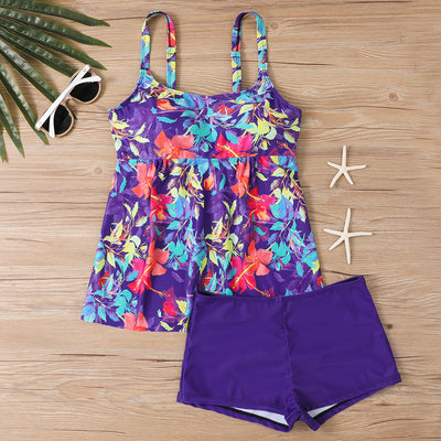 Woman in a black and white abstract print tankini top with black swim shorts on a sunny beach. - Image 20