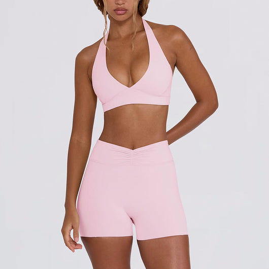 Light pink halter neck sports bra and high-waisted leggings workout set on a model. - Image 23