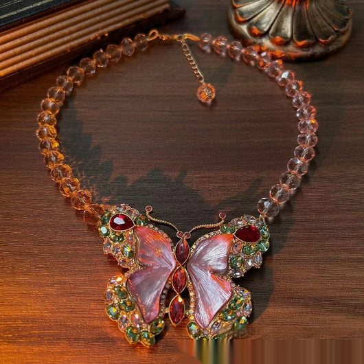 Pink enamel butterfly brooch with green, red, and clear rhinestones set in gold-toned metal. - Image 3