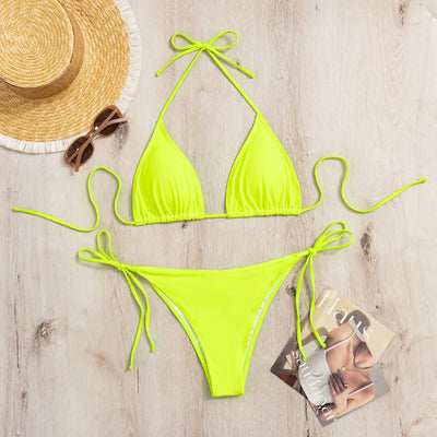 Neon yellow halter bikini with triangle top and tie-side bottoms, displayed on a light wood surface. - Image 21