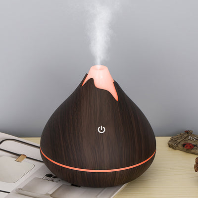 Teardrop-shaped aromatherapy humidifier with light wood grain finish, emitting mist and glowing with purple LED light. - Image 12